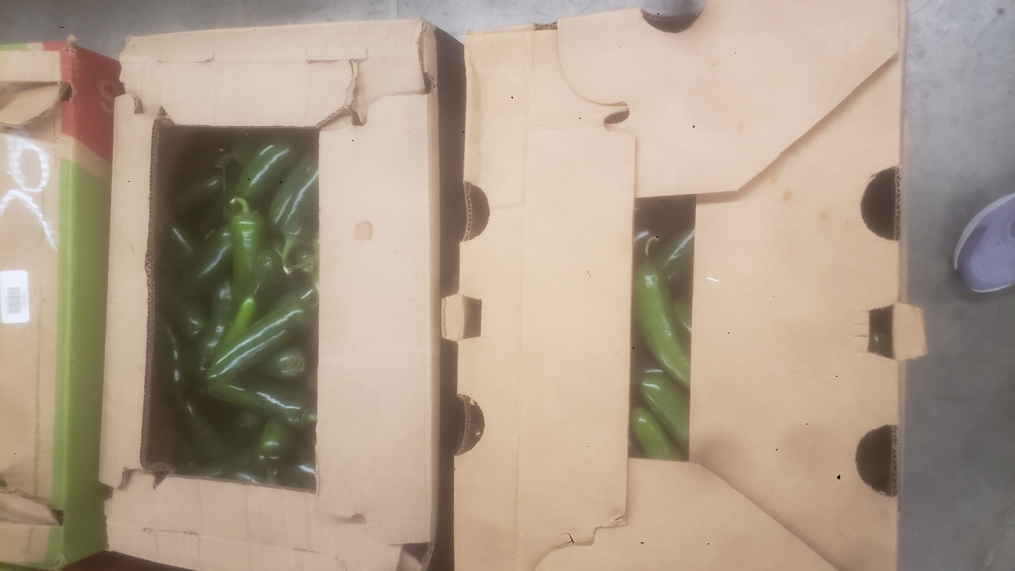 Produce box with jalapeño peppers peeking out.